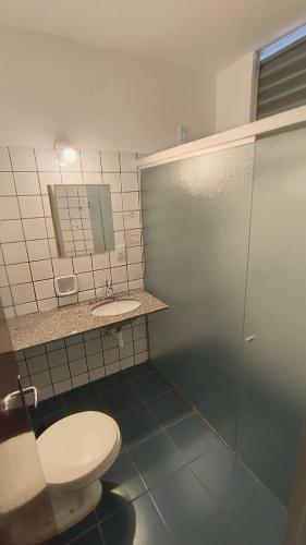 a bathroom with a toilet and a sink at Bravo City Hotel Birigui in Birigui