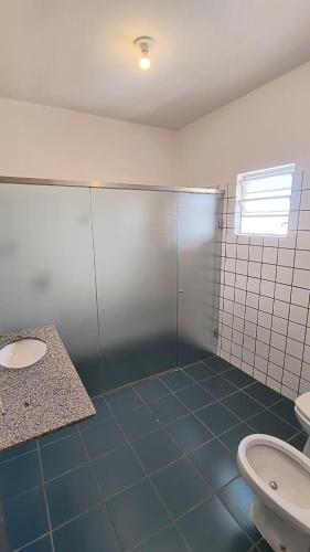 a bathroom with a shower and a sink and a toilet at Bravo City Hotel Birigui in Birigui