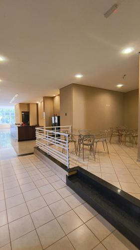 a lobby with tables and chairs in a building at Bravo City Hotel Birigui in Birigui