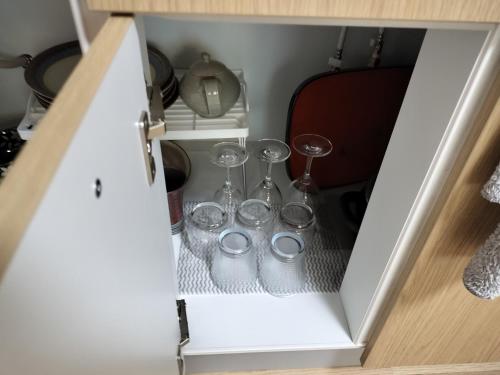 ein Schrank mit zwei Gläsern und zwei Weingläsern in der Unterkunft 源氏民宿 in Tokio
