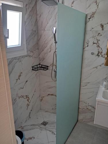 a bathroom with a marble shower with a window at Thea Rooftop in Skiathos