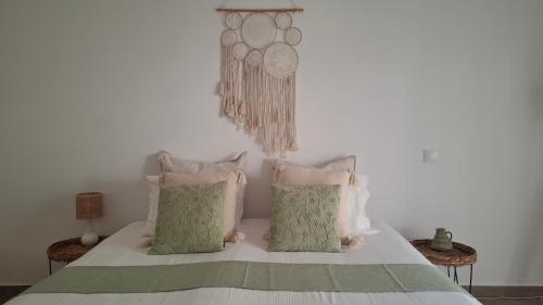 a bedroom with a bed with green and pink pillows at The Terrace House - Grémio in Olhão