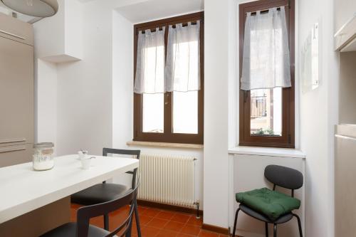 cocina con 2 sillas, mesa y 2 ventanas en Vecellio, rustico in centro a Trieste, en Trieste