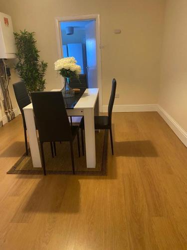 a dining room table with chairs and a vase of flowers at LHChomeway in Earley
