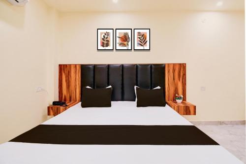 a bedroom with a large bed with a black headboard at Hotel O Shree Krishna Palace in Nilmatha