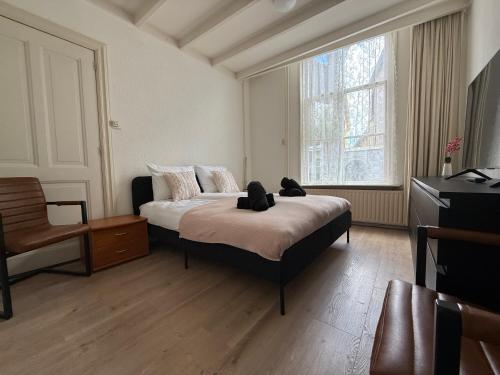 a bedroom with a bed with two teddy bears on it at Theislandlife 10p Centrum Texel in Den Burg