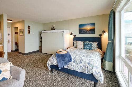 Un dormitorio con una cama y una ventana grande. en Oceanfront Studio - Ground Floor - Sleeps 4, en Lincoln City