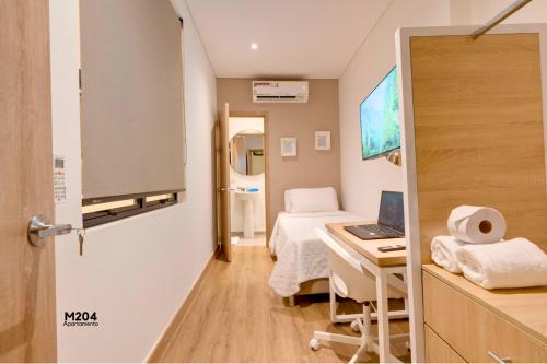 a hospital room with a bed and a desk with a laptop at Magusan Holiday Rentals in Cali