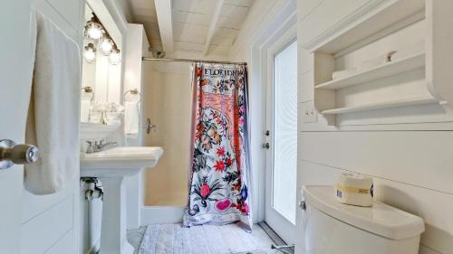 a bathroom with a shower curtain and a toilet at Coastal Cottage in Anna Maria