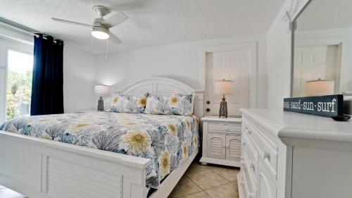 a white bedroom with a bed and a window at Coastal Cottage in Anna Maria
