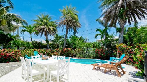 a patio with a table and chairs next to a pool at Coastal Cottage in Anna Maria