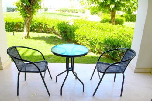 tres sillas y una mesa de cristal con una mesa y sillas en روتانا, en Salalah
