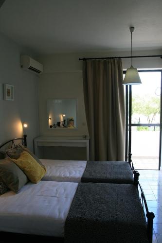 a bedroom with two beds in front of a window at Vasilina in Faliraki