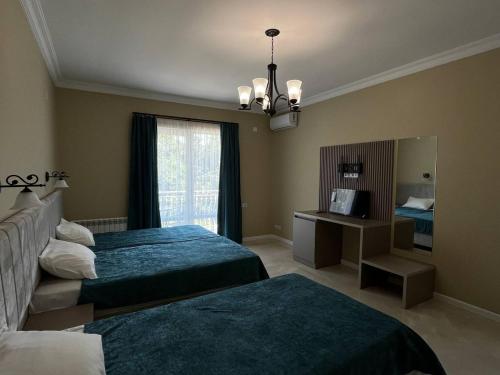 a hotel room with two beds and a mirror at Гостевой дом Добрые Традиции Good Traditions Guest House in Itʼkhvisi