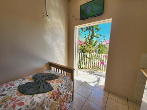 a bedroom with a bed and a sliding glass door at Économique Hotel in Ilha Solteira