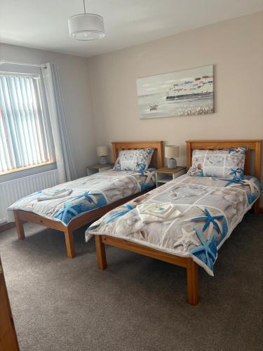 two beds sitting next to each other in a bedroom at Coastal Comforts in Newcastle