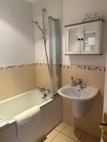 a bathroom with a bath tub and a sink at Coastal Comforts in Newcastle