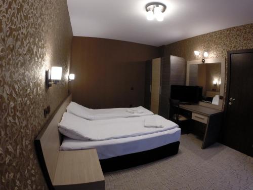 Una habitación de hotel con dos camas y un escritorio. en VIP Apartments Dobrevi, en Primorsko