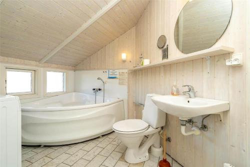 a bathroom with a tub and a toilet and a sink at 150-Ringkobing-Krogen-8 in Ringkøbing