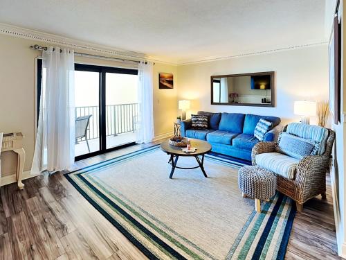 a living room with a blue couch and a table at Bent Palm 218 in Ormond Beach