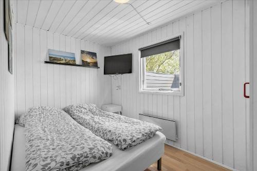 a small bedroom with a bed and a window at 081-Ringkobing-P-Snejkers-Vej-13 in Ringkøbing