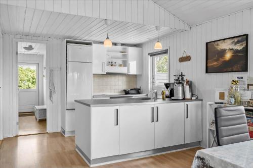 a kitchen with white cabinets and white appliances at 081-Ringkobing-P-Snejkers-Vej-13 in Ringkøbing