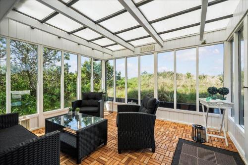a screened in porch with furniture and windows at 081-Ringkobing-P-Snejkers-Vej-13 in Ringkøbing