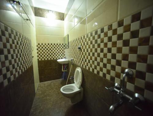 a bathroom with a toilet and a sink at PRM Aruna Lodge in Erode
