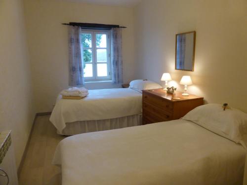 a bedroom with two beds and a window at Le Petit Souhait & Le Verger in Gourvillette