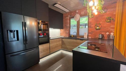a kitchen with a stainless steel refrigerator and a counter at Domki i dom w sadzie Stegna z podgrzewanym basenem - prywatne jacuzzi przy domu in Stegna