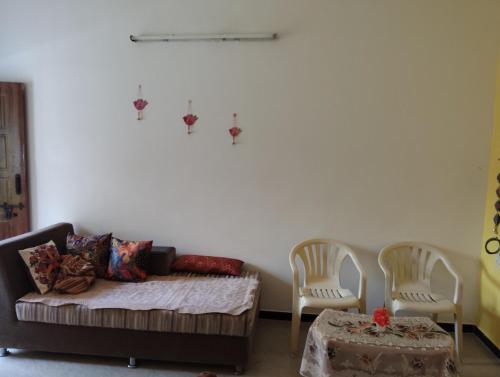 a living room with a couch and two chairs and a table at A Cozy Homestay in Coimbatore in Coimbatore
