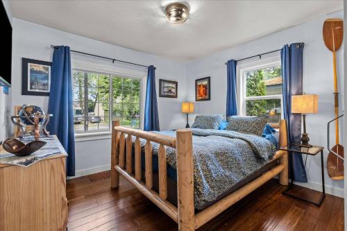 a bedroom with blue curtains and a bed and a window at Blue Door Breeze in Coeur d'Alene