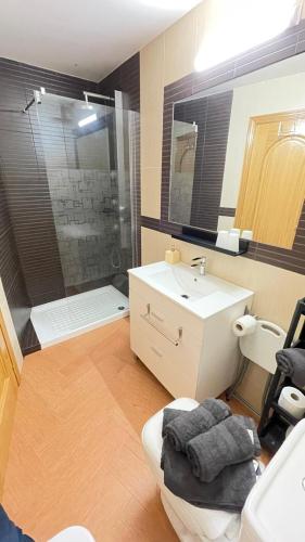 a bathroom with a sink and a toilet and a shower at APARTAMENTOS TURíSTICOS MONTASOL 2 in Montánchez