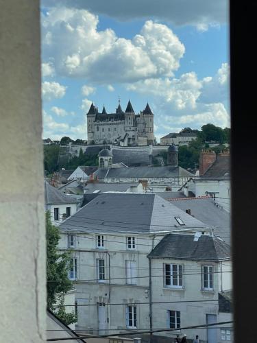 a castle on top of a city with buildings at La pause Saumuroise in Saumur
