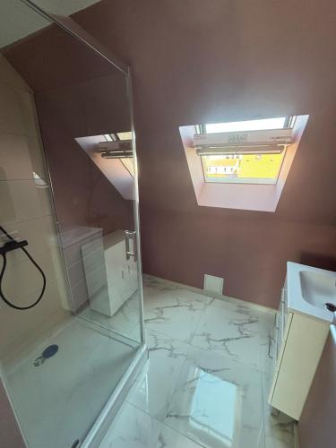 a bathroom with a glass shower and a sink at Chez Julie & Yvon in Le Portel