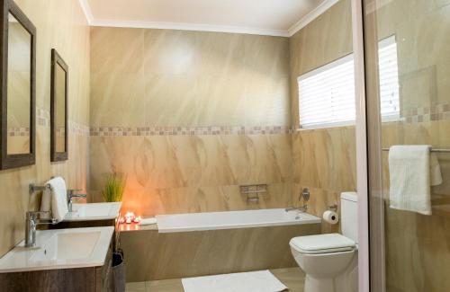 a bathroom with a tub and a toilet and a sink at Valhalla on Knelsby in Hillcrest