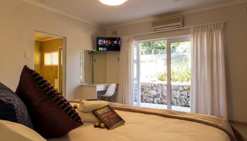 a bedroom with a bed and a sliding glass door at Valhalla on Knelsby in Hillcrest