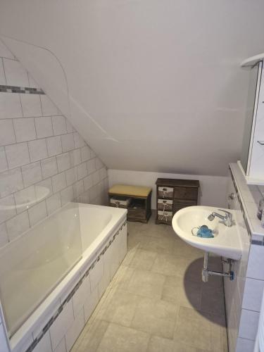a white bathroom with a tub and a sink at Dorfblick Vacation Rental in Ilsede