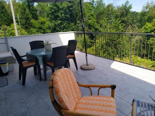 a patio with a table and chairs and an umbrella at Paradiso Nascosto del Lago Maggiore in Colazza