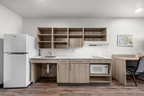 a kitchen with a sink and a refrigerator at WoodSpring Suites Charlotte - Arrowood in Charlotte