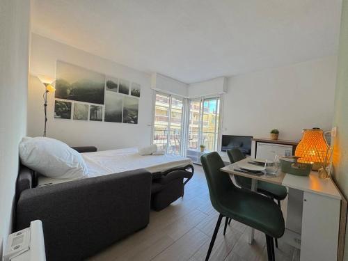 Un dormitorio con una cama y un escritorio con una computadora. en Calme et ensoleillé balcon quartier Port Nice, en Niza