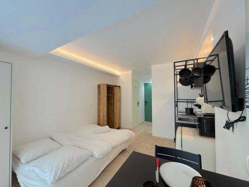 une chambre avec un lit, un bureau et une télévision dans l'établissement Studio Vieux-Nice climatisé: charme commodités, à Nice