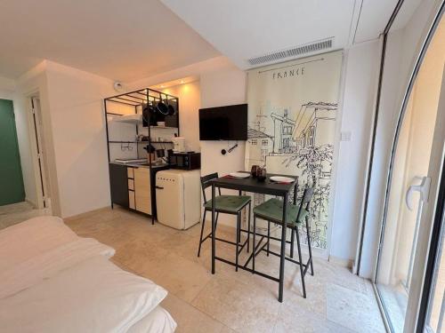 une petite cuisine avec une table et des chaises dans une pièce dans l'établissement Studio Vieux-Nice climatisé: charme commodités, à Nice