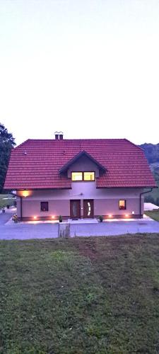 a large house with a red roof on a field at Apartmaji Božiček in Podčetrtek