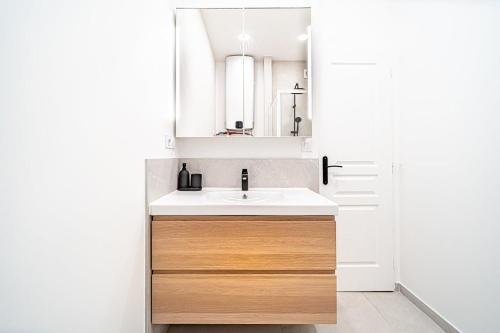 une salle de bain avec un lavabo et un miroir dans l'établissement T2 Spacieux : Wi-Fi cuisine équipée profamille, à Villeurbanne
