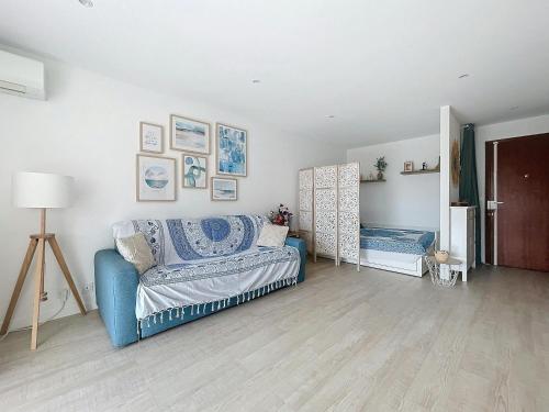 un salon avec un canapé bleu et une table dans l'établissement Blue sky-Plage 2min-Plein Sud, au Golfe-Juan