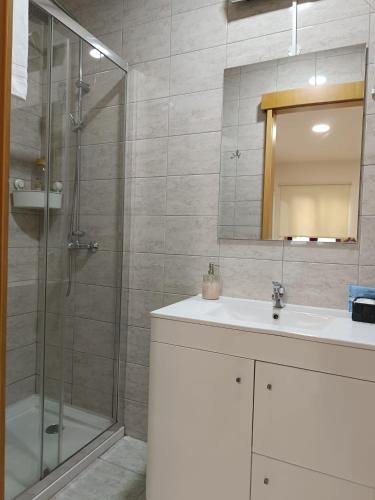 a bathroom with a shower and a sink and a mirror at Portus Ribeira House in Vila Nova de Gaia