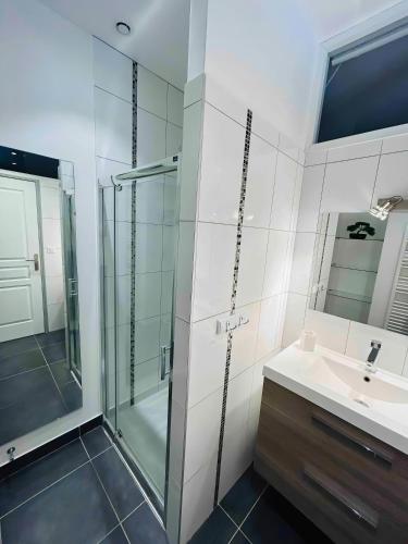 une salle de bain avec une douche en verre et un lavabo dans l'établissement LEtape Prestige Hyper-Centre Calme, à Reims