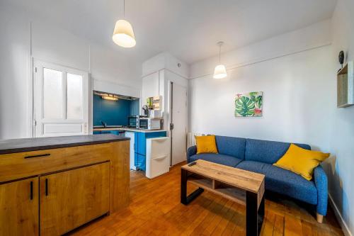 un salon avec un canapé bleu et une table dans l'établissement Lescapade Blue and Yellow 10min to Paris, à Épinay-sur-Seine