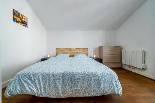 une chambre avec un lit avec une couverture bleue dans l'établissement Lescapade Blue and Yellow 10min to Paris, à Épinay-sur-Seine
